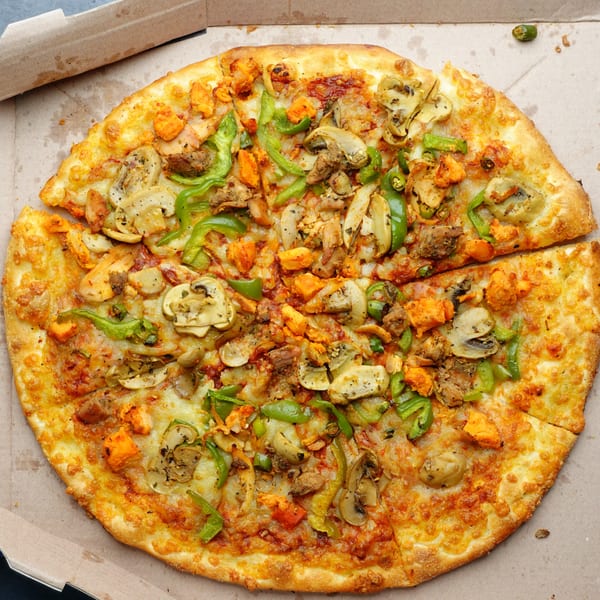 Tommy's Pizza and Pasta's chicken, mushroom, and green pepper pizza in a cardboard box.